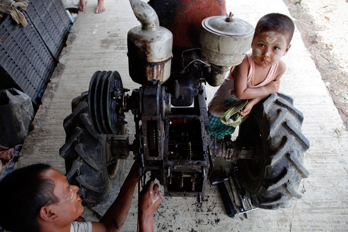Một người thợ sửa xe máy kéo cho nông dân ở Kyaiklat, Myanmar, 24/05/2012.