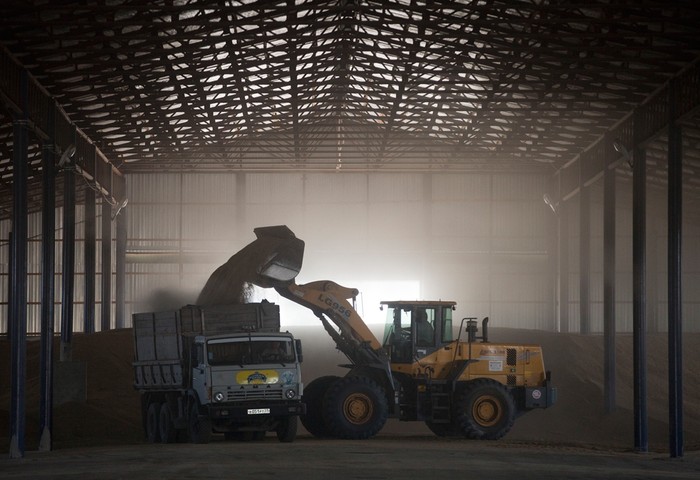Hạt lúa mì được chuyển lên thùng xe tải bằng xe máy xúc tại một nhà kho ở Krasnodar, Nga, 13/07/2012.