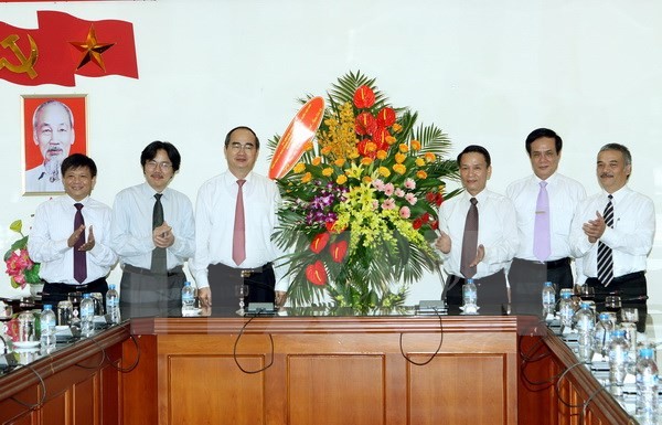 Chủ tịch UBTW Mặt trận Tổ quốc Việt Nam Nguyễn Thiện Nhân tặng hoa chúc mừng TTXVN. (Ảnh: Nguyễn Dân/TTXVN)