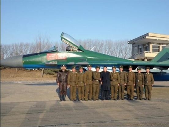 Ông Kim Jong-ul tích cực thể hiện "tài năng quân sự" thông qua việc tăng cường thị sát các đơn vị quân đội. Trong hình là ông Kim Jong-ul chụp ảnh với các binh sĩ Không quân bên cạnh máy bay chiến đấu MiG-29