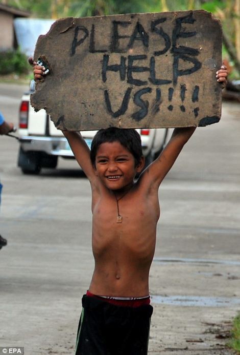 Lời kêu cứu của một em bé Philippines đang giơ cao tấm biển xin cứu giúp 12/11/2013