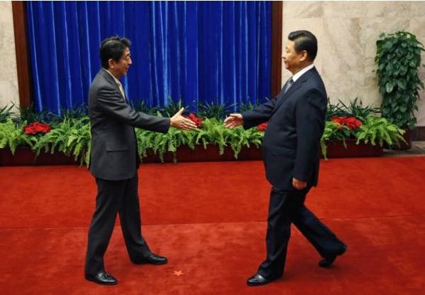 Ông Tập Cận Bình (phải) và ông Shinzo Abe bắt tay nhau