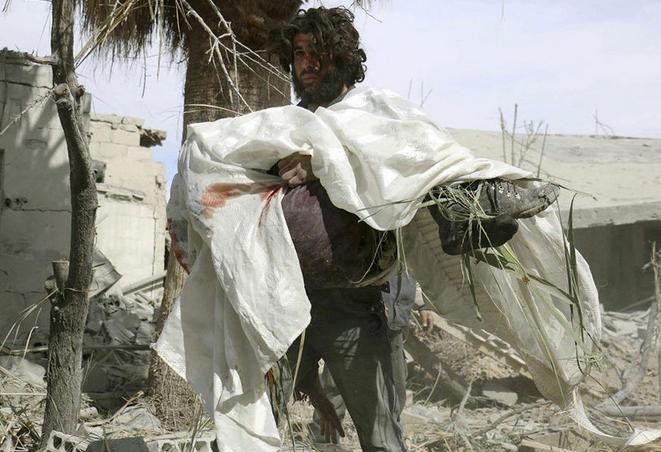 Một người đàn ông Syria ôm thi thể mẹ