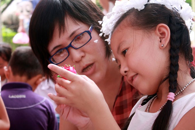 Với sản phẩm đầu tay của mình là quả thanh long, Khánh Linh đang khoe với mẹ của mình.