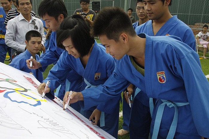 Những môn sinh thay nhau ký tặng vào lá cờ Olympic gửi tới đội tuyển Vovinam quốc gia.