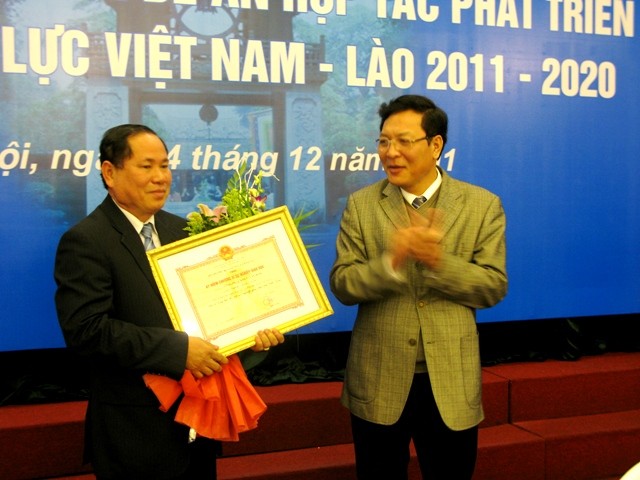 Bộ trưởng Phạm Vũ Luận trao kỷ niệm chương cho Đai sứ quán Lào tại Việt Nam. Ảnh Xuân Trung