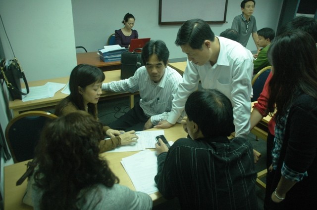 Phụ huynh học sinh, sinh viên hội ý trước khi tiếp tục "chất vấn" lãnh đạo Raffles. Ảnh Xuân Trung