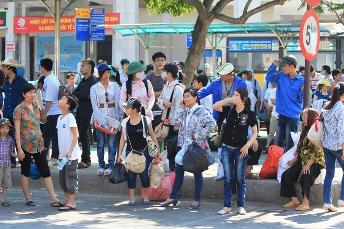 Dưới cái nắng như đổ lửa của Hà Nội, nhiều sinh viên núp dưới bóng cây đợi xe buýt về nhà trọ sau đợt nghỉ lễ