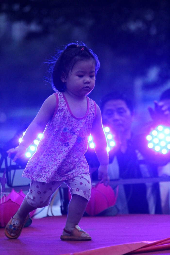 Tại các quận, huyện ở Hà Nội những ngày này thường dựng các sân khấu ngoài trời để tổ chức Tết trung thu các các cháu, trong ảnh là một bé gái nô đùa trước ánh đèn điện tại một sân khấu ngoài trời của Quận Cầu Giấy.