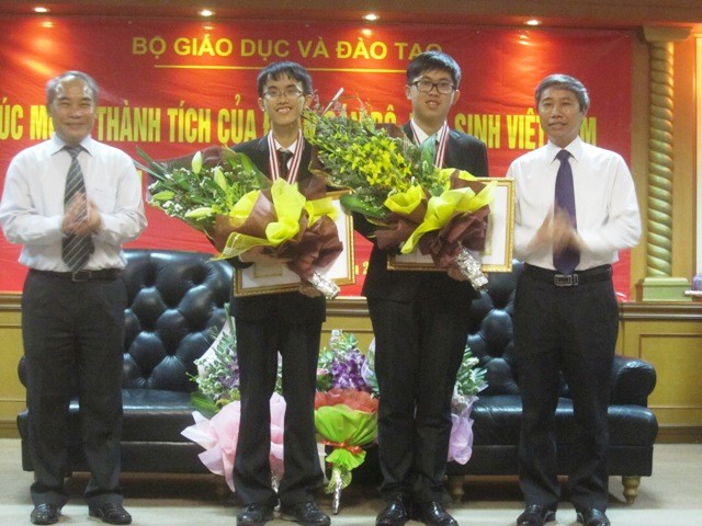 Bùi Quang Tú (thứ 2 từ trái sang) và Ngô Phi Long là những HCV Vật lí châu Á, nhận bằng khen và hoa từ Bộ GD&ĐT. Ảnh Xuân Trung