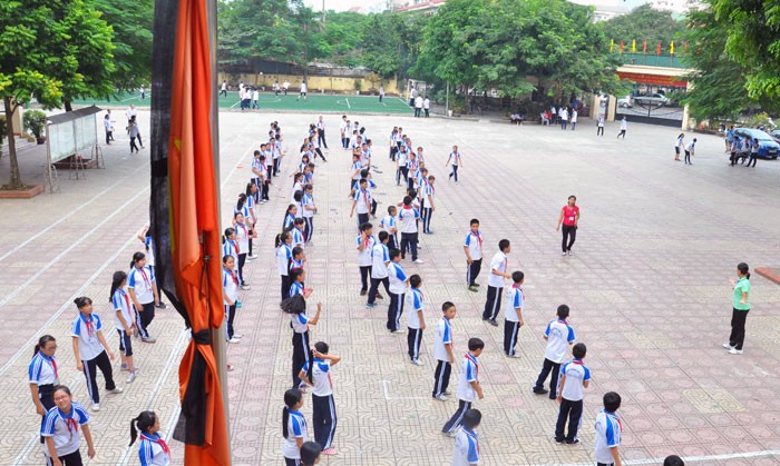 Học sinh tập thể dục dưới cờ Quốc tang.
