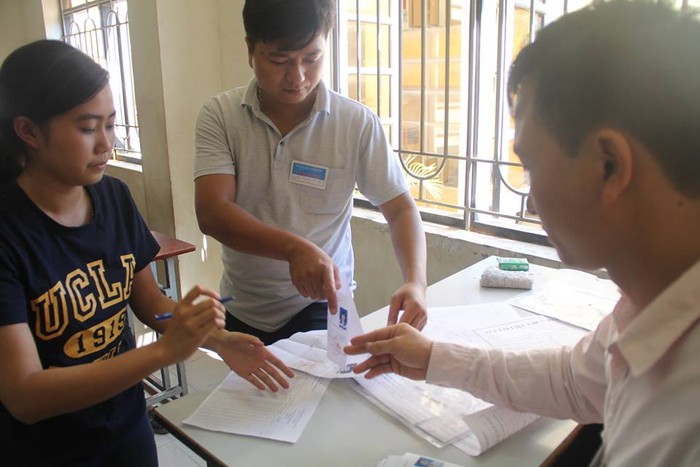 Thí sinh đối chiếu thông tin cá nhân trước khi nhận thẻ dự thi tại Đại học Công nghiệp Hà Nội. Ảnh Xuân Trung