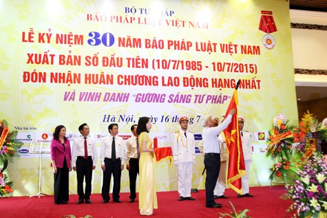 Đồng chí Uông Chu Lưu, Ủy viên Trung ương Đảng, Phó chủ tịch Quốc hội lên trao Huân chương cho đội ngũ lãnh đạo báo Pháp luật Việt Nam. Ảnh Pháp luật Việt Nam.