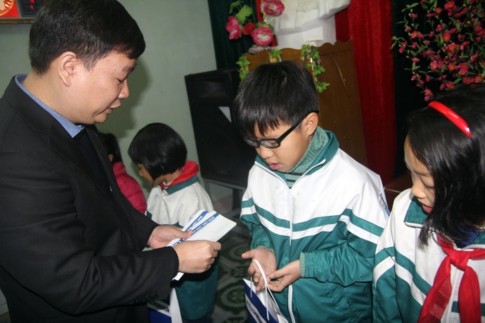 Ông Nguyễn Tiến Bình trao quà cho học sinh nghèo vượt khó của phường Trường Thịnh.