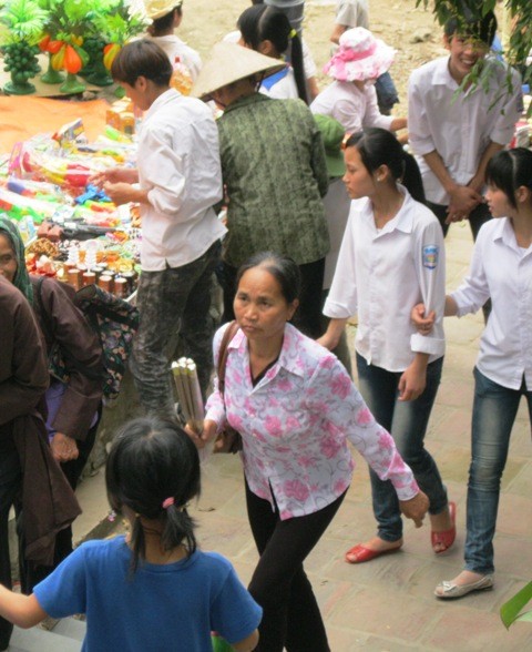 Bé gái (áo xanh) khá xinh xắn, du khách vẫn thường bắt gặp bé này khi đi lễ hội Chùa Hương..(ảnh: Hải Sơn)