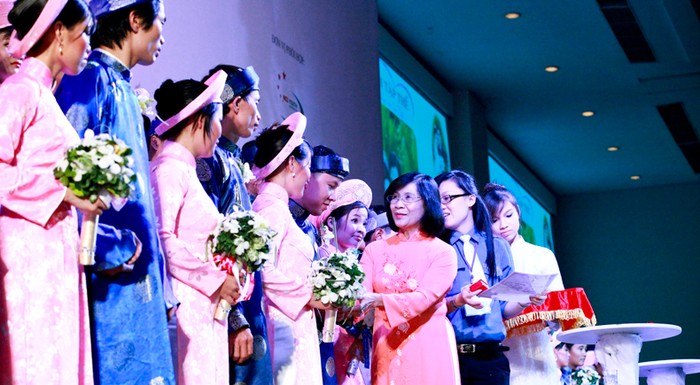 Bà Nguyễn Thị Thu Hà, phó bí thư Thành uỷ TP.HCM trao giấy chứng nhận kết hôn và nhẫn cưới cho các cặp đôi. Ảnh: Hồng Thái (Sài gòn tiếp thị).