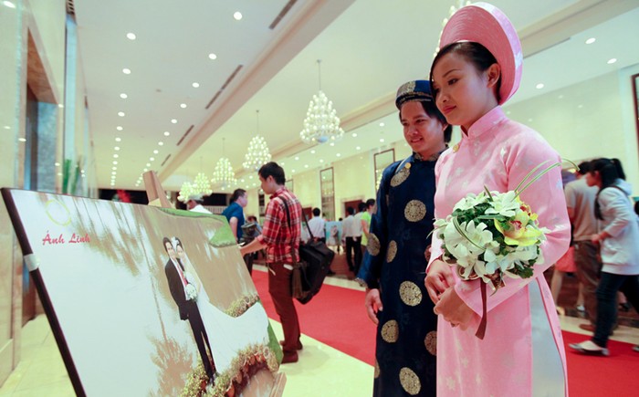 Một cặp dừng lại xem hình chụp của hình trước khi vào lễ cưới. Ảnh: Hồng Thái (Sài gòn tiếp thị).