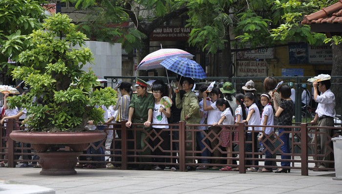Nhiều người đã dùng ô để làm giảm đi cái nắng trên con đường vào lăng.