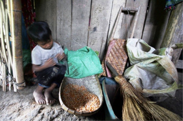 Em bé ngồi chơi với rổ ngô, thức ăn chính của gia đình trong những ngày giáp hạt