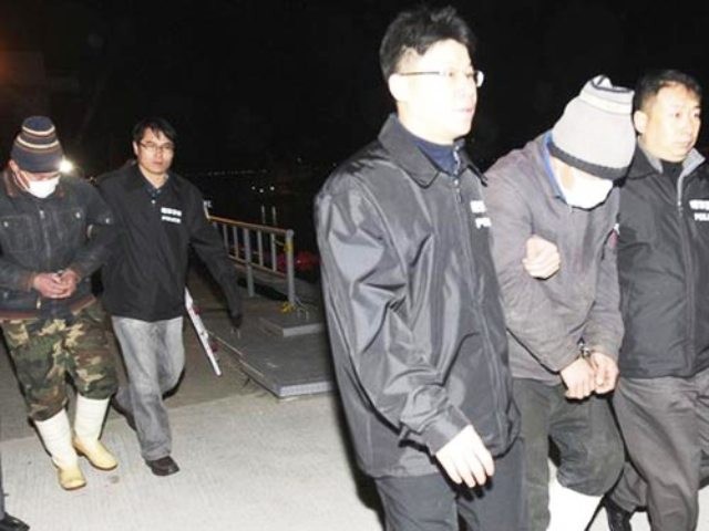 Cảnh sát Hàn Quốc giải những ngư dân Trung Quốc bị bắt gần đây vì đánh bắt cá trái phép Ảnh: Reuters