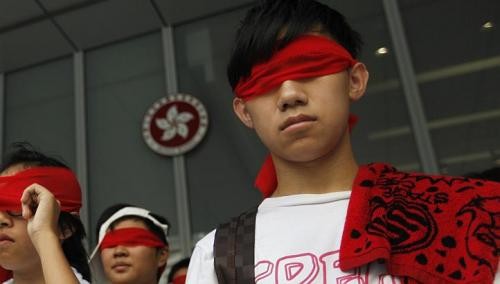Các học sinh dùng băng đỏ che mặt phản đối kiểu giáo dục "bịt mắt"