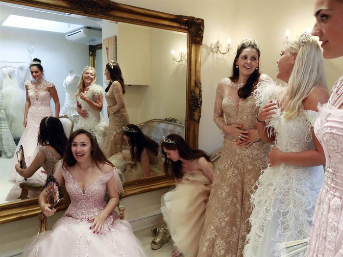 Từ trái qua phải Debutantes, Maria Austin, Amelia Simmons, Sophie Bonello, Zoe Rawson, và Georgina Riddle thử một chiếc váy phù hợp để dự buổi khiêu vũ Nữ hoàng Charlotte ở London, ngày 25 tháng 7, hình ảnh MSNBC nhận được ngày 26/9