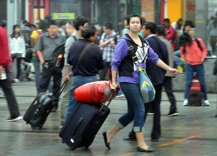 Một cô gái kéo hành lý ra khỏi nhà ga xe lửa Trịnh Châu, thủ phủ tỉnh Hà Nam, Trung Quốc