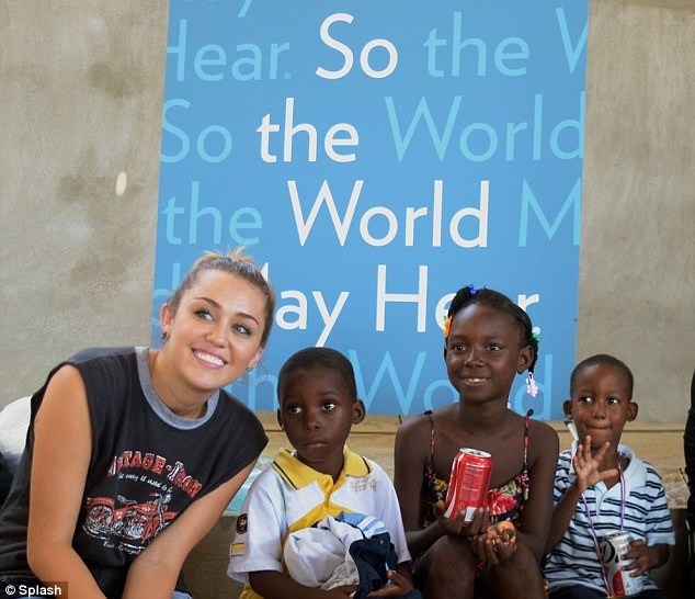 Miley Cyrus chụp hình cùng các fan hâm mộ nhí ở Haiti.