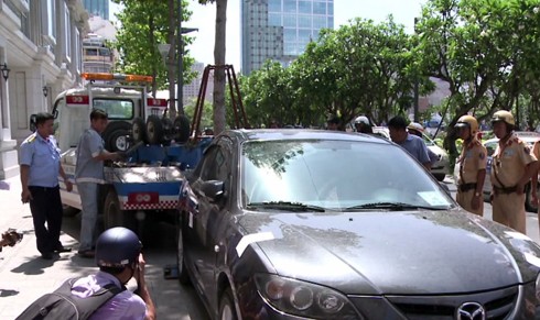 Lực lượng chức năng quận 1 xử lý xe ô tô đậu trên vỉa hè, chiếm lề đường người đi bộ. (Ảnh: Đ.Q)