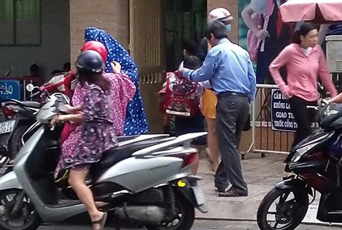 Thầy Nguyễn Văn Hùng (áo xanh) đang dắt học sinh băng sang đường. (Ảnh: N.V.H)
