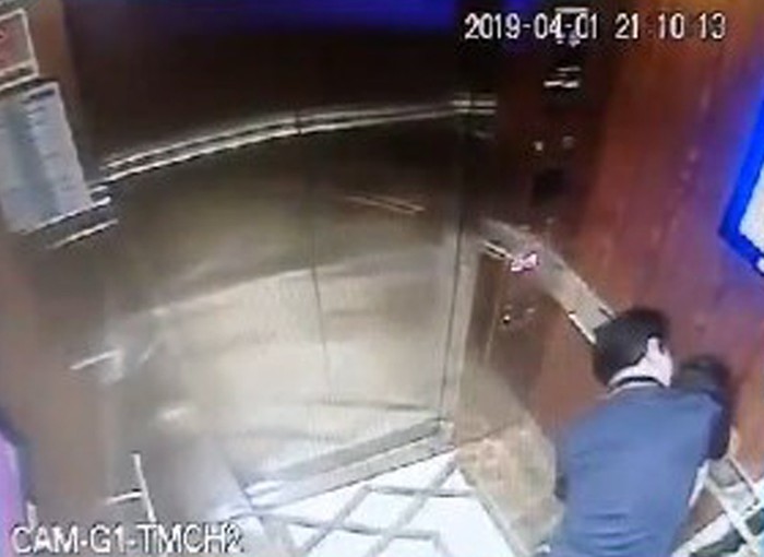 Hình ảnh người đàn ông ôm ấp bé gái trong thang máy qua màn hình camera. (Ảnh cắt từ clip)