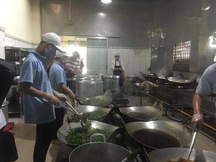 Công nhân đang chế biến thức ăn nấu sẵn, như: Đậu que xào, gà kho sả ớt, cá diêu hồng kho… (Ảnh: T.M)