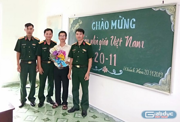 Thầy Bành Hữu Tình nhận đóa hoa tươi thắm từ các chiến sĩ Trường Sa. (Ảnh: H.T)