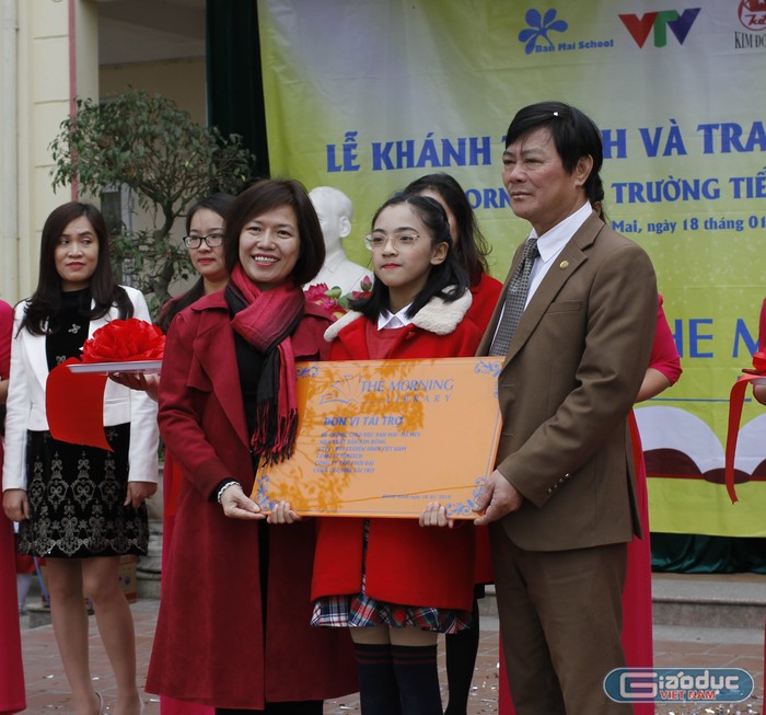 Cô Mai Thị Lan Anh trao biển thư viện The Morning V cho thầy Nguyễn Đình Cư - Hiệu trưởng trường Tiểu học Đồng Mai II. Ảnh: Đ.T