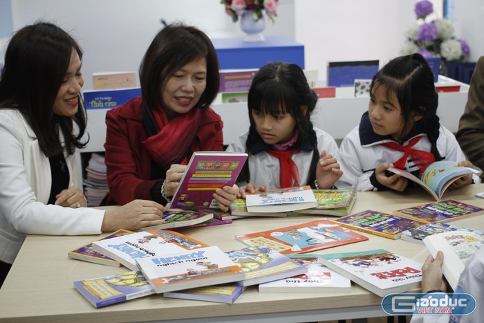 Cô Mai Thị Lan Anh (áo đỏ) trò truyện, chia sẻ về những cuốn sách cùng các em học sinh Tiểu học Đồng Mai. Ảnh: Đ.T