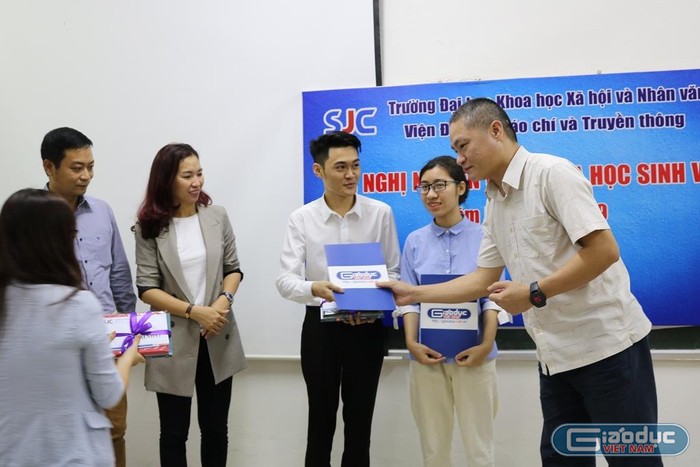 Nhà báo Đào Ngọc Tước tặng quà động viên hai sinh viên đạt giải nhất. Ảnh: Đỗ Thơm