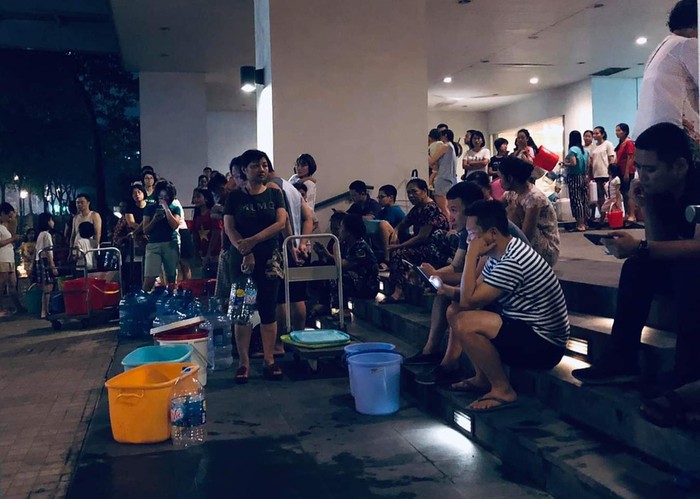 Cảnh tượng người dân xếp hàng lấy từng xô nước miễn phí như thời bao cấp. Ảnh:Nam Dương/giaoduc.net.vn