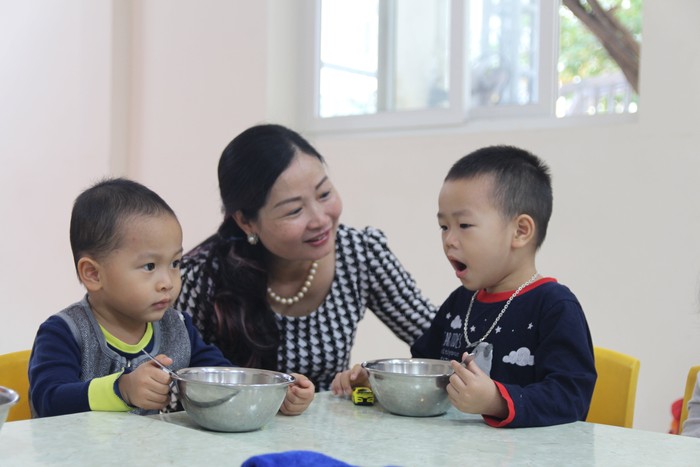 Cô Trương Thị Minh Phượng – Hiệu trưởng nhà trường chăm sóc các con trong bữa ăn sáng đầu tiên ở trường. Ảnh tư liệu: Nhà trường cung cấp