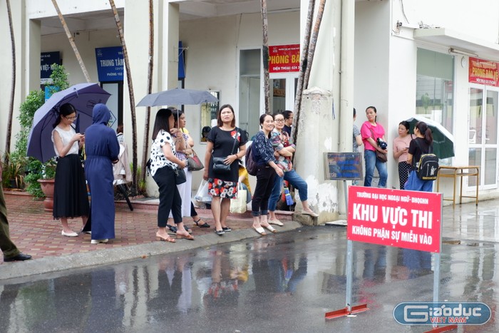 Dù trời mưa, nhưng rất nhiều phụ huynh vẫn túc trực ở cổng trường để đợi con. Ảnh: Quỳnh Trang - Diệu Thùy.