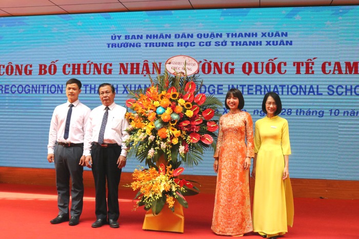 Lãnh đạo Sở Giáo dục và Đào tạo Hà Nội tặng hoa chúc mừng nhà trường. Ảnh: Đ.T