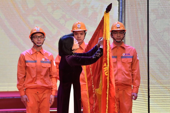 Phó Chủ tịch nước Đặng Thị Ngọc Thịnh gắn danh hiệu Anh hùng Lao động thời kỳ đổi mới lên lá cờ truyền thống của EVN. Ảnh: VGP/Nhật Bắc