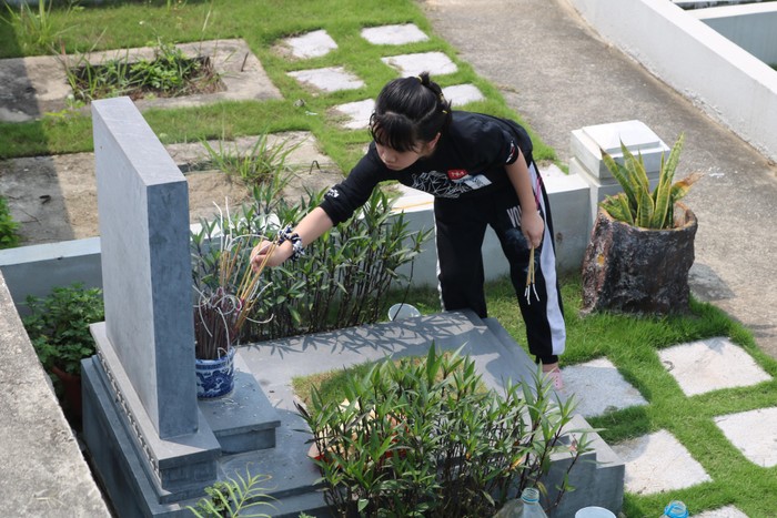 Nhiều trẻ nhỏ chủ động thắp hương cho các phần mộ xung quanh phần mộ của gia đình.