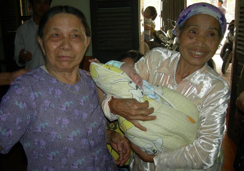 Sau gần nửa tháng chào đời, bé Hà mới được trở về nhà. Bà nội bé (bên trái) và bà trẻ cười rất tươi khi được bế cháu.