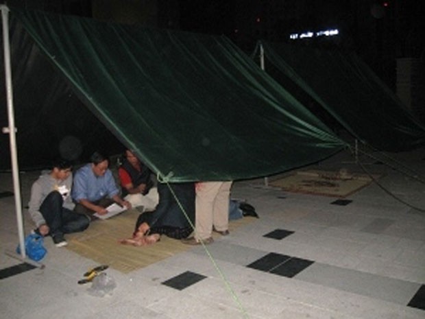 Người dân chung cư Keangnam (Hà Nội) dựng lều bạt tại sảnh chính để ngủ qua đêm, tối 3.12.2011, do bị ban quản lý chung cư cắt dịch vụ thang máy. Ảnh: Vietnam+