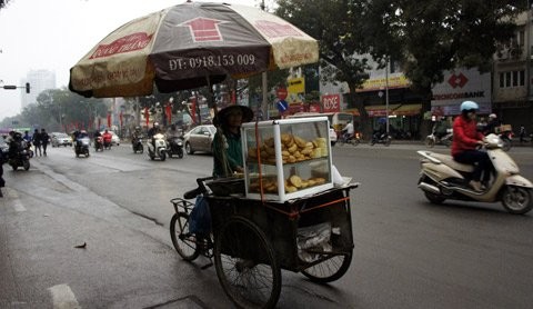 Xe hàng rong mang cả ô để che mưa