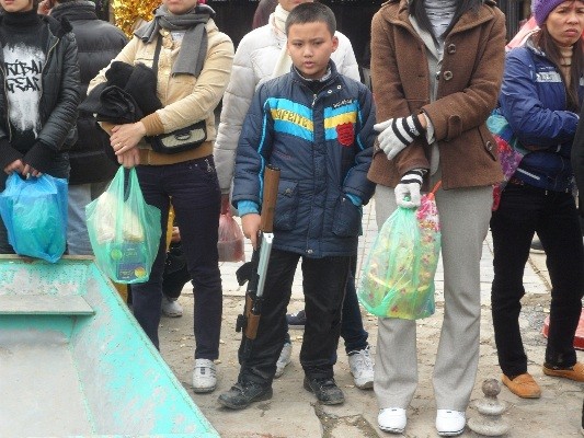 Còn cậu bé này được bố mẹ mua cho một khẩu súng làm quà khi đi lễ phật tại chùa Hương.