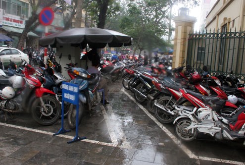 Các bãi trông xe trước cổng bệnh viện Phụ sản Trung ương (phố Triệu Quốc Đạt) vẫn hoạt động như bình thường. Ảnh: Nguyễn Lê.