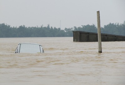 Chiếc xe Innova bị lũ cuốn được người dân địa phương cột lại nên nước không thể cuốn trôi