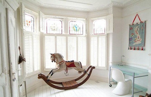 Phòng ngủ được thiết kế với những cánh cửa sổ liền sát nhau đón ánh nắng khắp phòng với chú ngựa gỗ lạ mắt