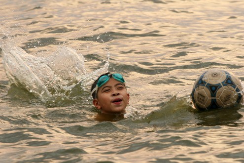 Em bé này mang cả bóng để làm phao bơi và đùa nghịch.